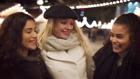 Portrait-Of-Female-Friends-Enjoying-Christmas-Market-At-Night