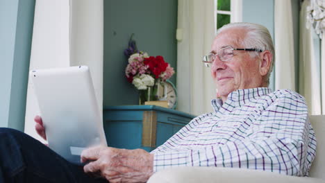 Glücklicher-älterer-Mann,-Der-Zu-Hause-Einen-Tablet-Computer-Benutzt