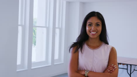 Young-mixed-race-businesswoman-walks-into-focus-in-an-office