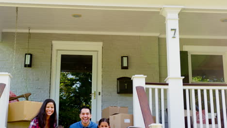 Family-Sitting-On-Steps-Of-New-Home-On-Moving-In-Day