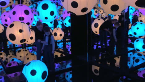 Visitors-in-Infinity-Mirrored-Room-with-colorful-illuminated-balls