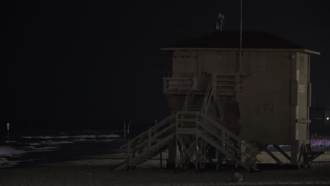 Rettungsschwimmerturm-Mit-Blinkendem-Licht-Am-Strand-Bei-Nacht