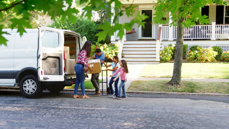 Children-Helping-Unload-Boxes-From-Van-On-Family-Moving-In-Day
