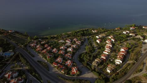 Flying-over-town-on-waterfront-and-blue-sea-Trikorfo-Beach-Greece