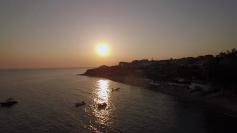 Sonnenuntergangsszene-Des-Resorts-Und-Des-Meeres-Mit-Booten-Aus-Der-Luft-Am-Trikorfo-Strand-In-Griechenland