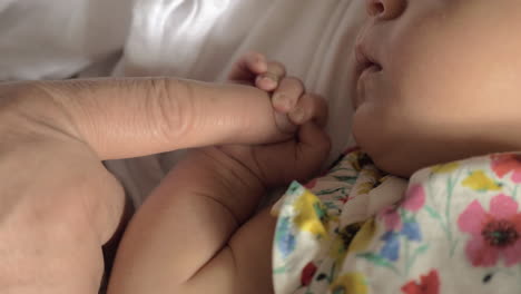 Baby-girl-holding-parents-finger