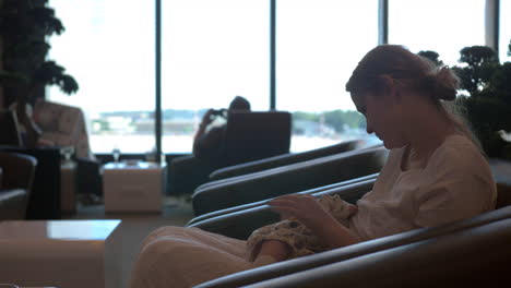 Mother-breastfeeding-baby-daughter-in-airport-lounge