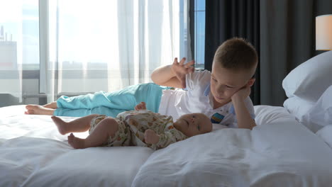 Boy-and-baby-sister-on-the-bed-at-home