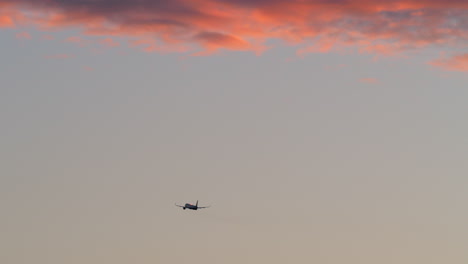 Flugzeug-Fliegt-Am-Abendhimmel-Mit-Roten-Wolken