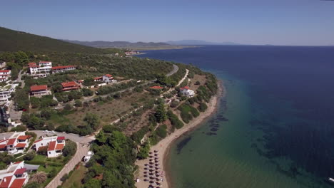 Flying-over-sea-cottages-and-resort-on-the-coast-Trikorfo-Beach-Greece
