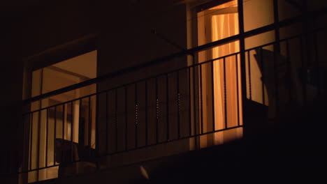 House-balcony-with-open-doors-at-night