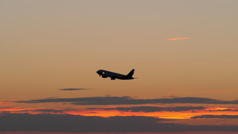 Black-silhouette-of-flying-airplane-in-the-evening-sky