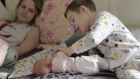 Boy-with-newborn-sister-at-home-in-the-morning