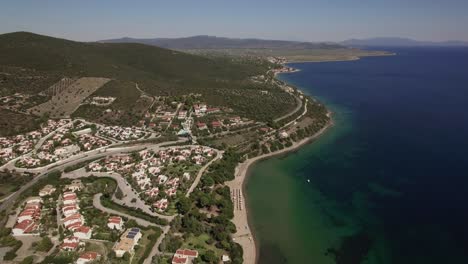 Aerial-scene-of-sea-coastline-and-Trikorfo-Beach-with-green-hills-Greece