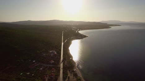 Flug-über-Meer-Und-Küste-Mit-Straße-Entlang-Des-Strandes-Von-Trikorfo-Am-Wasser-In-Griechenland