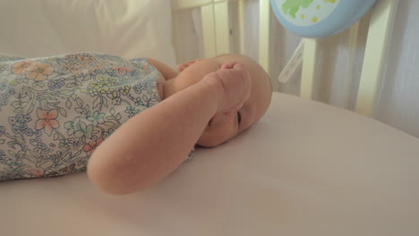 Newborn-girl-in-crib-before-daytime-sleep