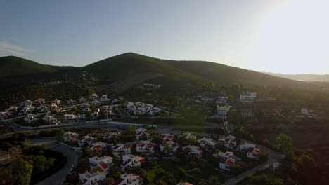 Aerial-view-of-neighbourhood-at-the-bottom-of-green-hills-Greece