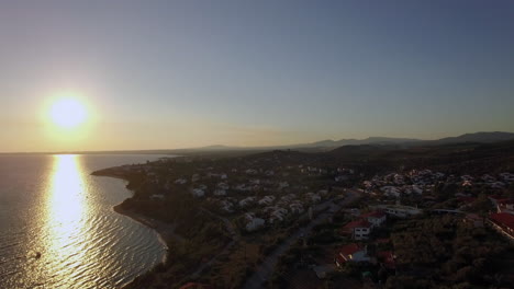 Aerial-sunset-scene-of-sea-and-coastline-with-houses-in-Trikorfo-Beach-Greece