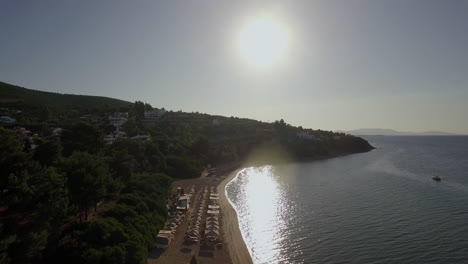 Luftaufnahme-Des-Resorts-Mit-Sonnenliegen-Am-Ufer-Im-Hellen-Sonnenlicht-Griechenlands