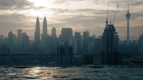 Zeitraffer-Ansicht-Des-Swimmingpools-Auf-Dem-Dach-Des-Wolkenkratzers-Vor-Sonnenaufgang,-Gebäude,-Stadtbild,-Kuala-Lumpur,-Malaysia