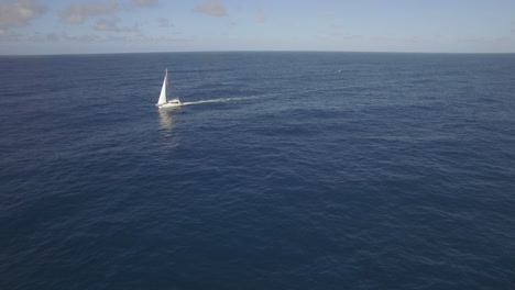Aerial-view-of-sailing-white-yacht-in-empty-ocean-blue-water-against-clear-sky-Mauritius-Island