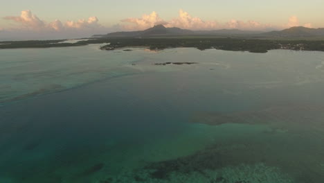 Vista-Aérea-Del-Agua-Azul-Del-Océano-Con-Olas,-Corales-Y-Plantas-Acuáticas,-Cámara-Que-Se-Mueve-A-La-Costa-De-La-Isla-Mauricio