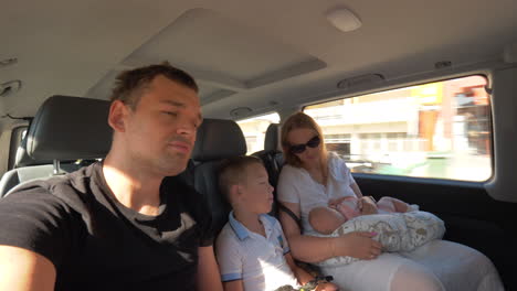 Family-of-four-traveling-by-car-in-the-city