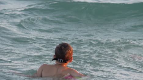 Child-is-happy-to-swim-on-sea-waves