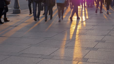 Bottom-view-of-people-legs-against-sunset-rays-on-the-paving-stone