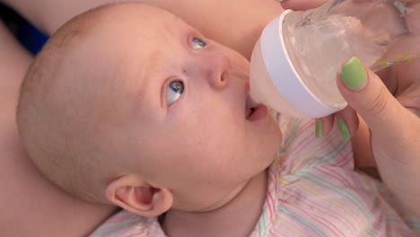 Mom-giving-baby-to-drink-water-from-the-bottle