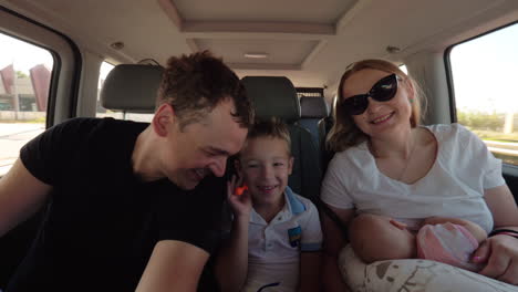 Happy-parents-with-elder-son-and-baby-daughter-having-car-journey