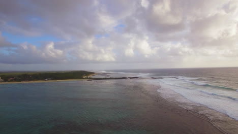 Aerial-view-of-water-line-of-seas-that-do-not-mix-against-blue-sky-with-clouds-Mauritius-Island