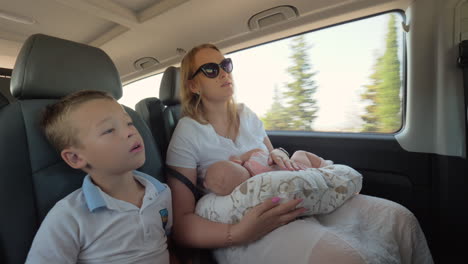 Mother-with-elder-son-and-baby-daughter-traveling-by-car