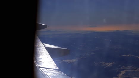 Aircraft-wing-and-picturesque-mountain-landscape-from-high-level-from-airplane-window
