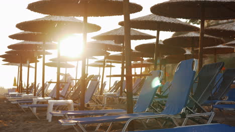Leere-Chaiselongues-Im-Resort-Und-Menschen,-Die-Den-Strand-Bei-Sonnenuntergang-Verlassen