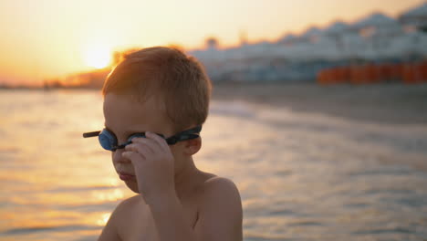 Child-in-goggles-is-going-to-bathe-at-sunset