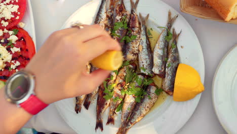 Eating-appetizing-sardines-dish-served-with-parsley-and-lemon