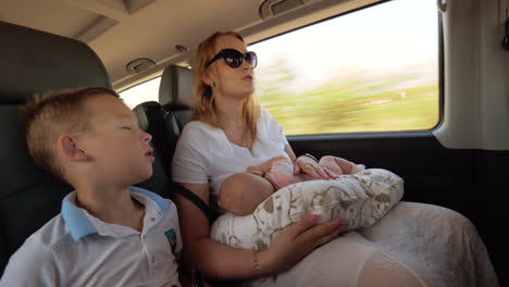 Mother-with-two-children-traveling-by-car