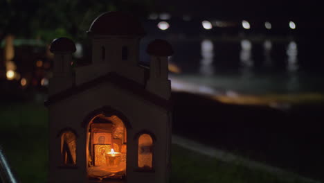Miniature-of-Greek-Orthodox-church-on-sea-front-at-night