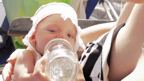 Baby-girl-drinking-water-from-bottle-outdoor