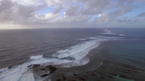 Aerial-view-of-water-line-of-seas-that-do-not-mix-against-blue-sky-with-clouds-Mauritius-Island