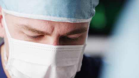 Male-healthcare-worker-in-scrubs,-head-shot,-looking-down