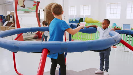 Two-boys-in-a-centrifugal-force-experiment-at-science-centre