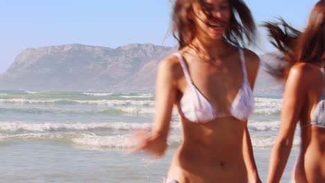 Freundinnen-Haben-Spaß-Daran,-Im-Strandurlaub-Durch-Die-Wellen-Zu-Laufen