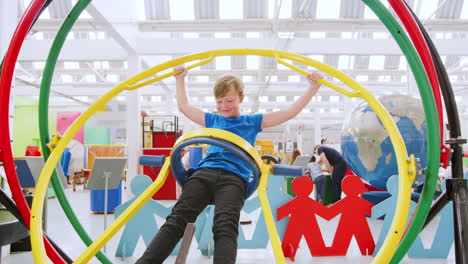 Young-boy-having-fun-on-human-gyroscope-at-a-science-centre