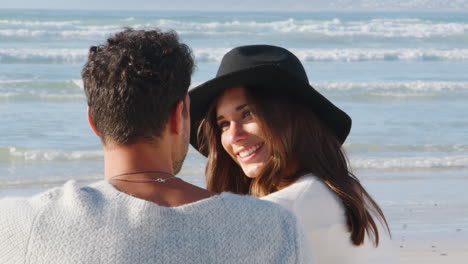 Rear-View-Of-Romantic-Couple-On-Winter-Beach-Vacation