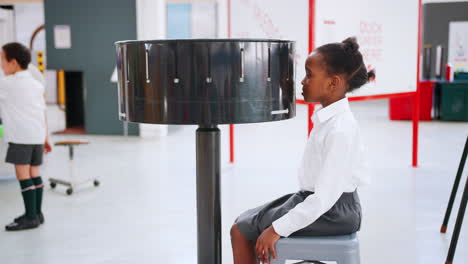 Young-black-girl-using-zoetrope-at-a-science-activity-centre