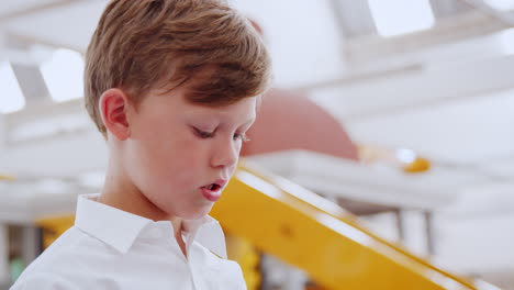 Young-white-boy-concentrating-at-science-centre,-close-up