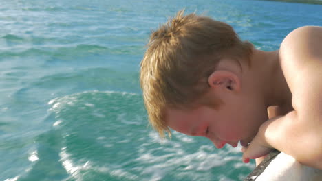 Child-traveling-by-boat-and-trying-to-touch-water