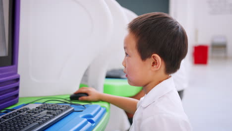 Asian-schoolboy-using-computer-at-a-science-activity-centre